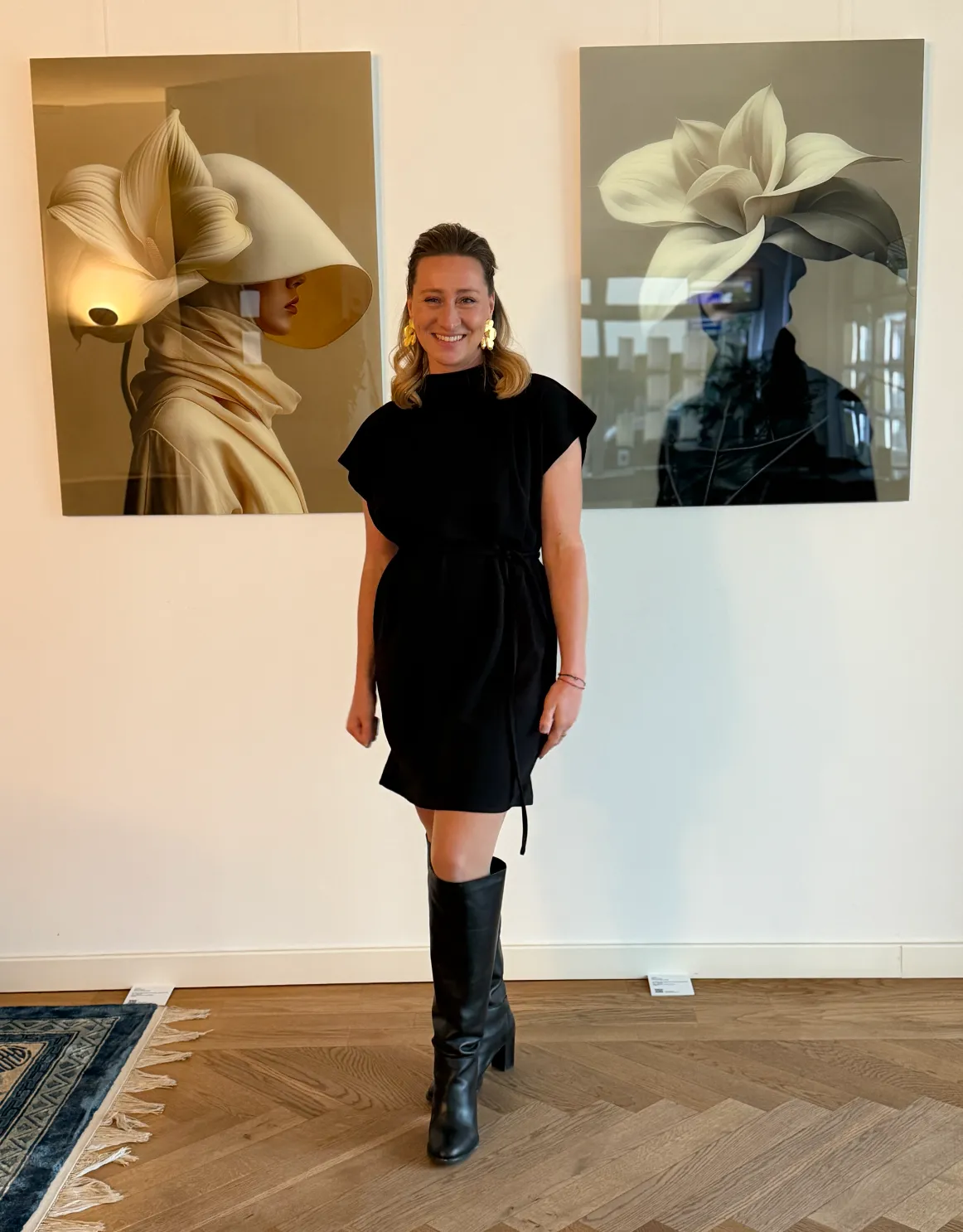 Janina Laszlo in 2026 standing between two works from her UNITY series at the exhibition at RE/MAX Collections Munich/Starnberg — German photographer and digital artist