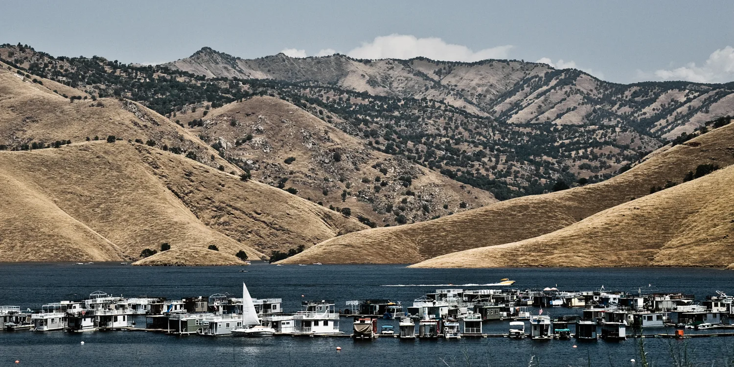 Houseboats on a reservoir beneath golden hills, California — US West Coast, panoramic fine art landscape photography by Janina Laszlo