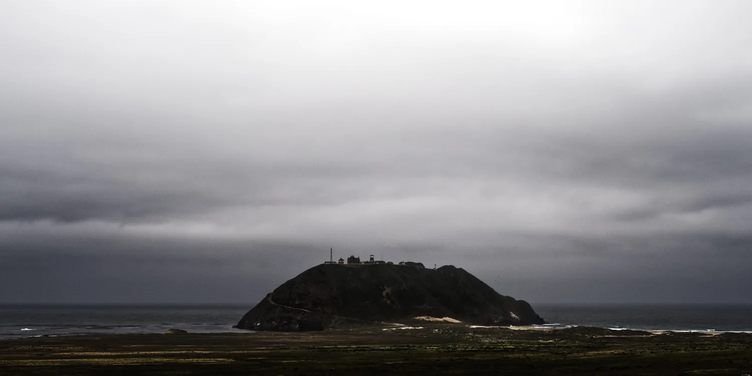 Point Sur Lighthouse on its volcanic rock under storm clouds, Big Sur coast, California — US West Coast, panoramic fine art landscape photography by Janina Laszlo