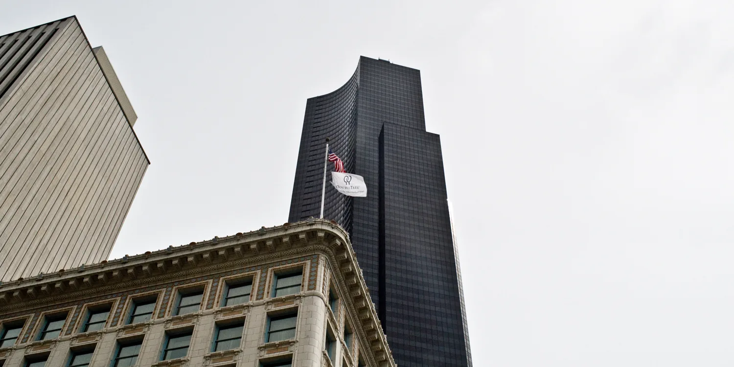 Columbia Center tower rising above a historic hotel with the US flag, downtown Seattle, Washington — US West Coast, panoramic fine art landscape photography by Janina Laszlo