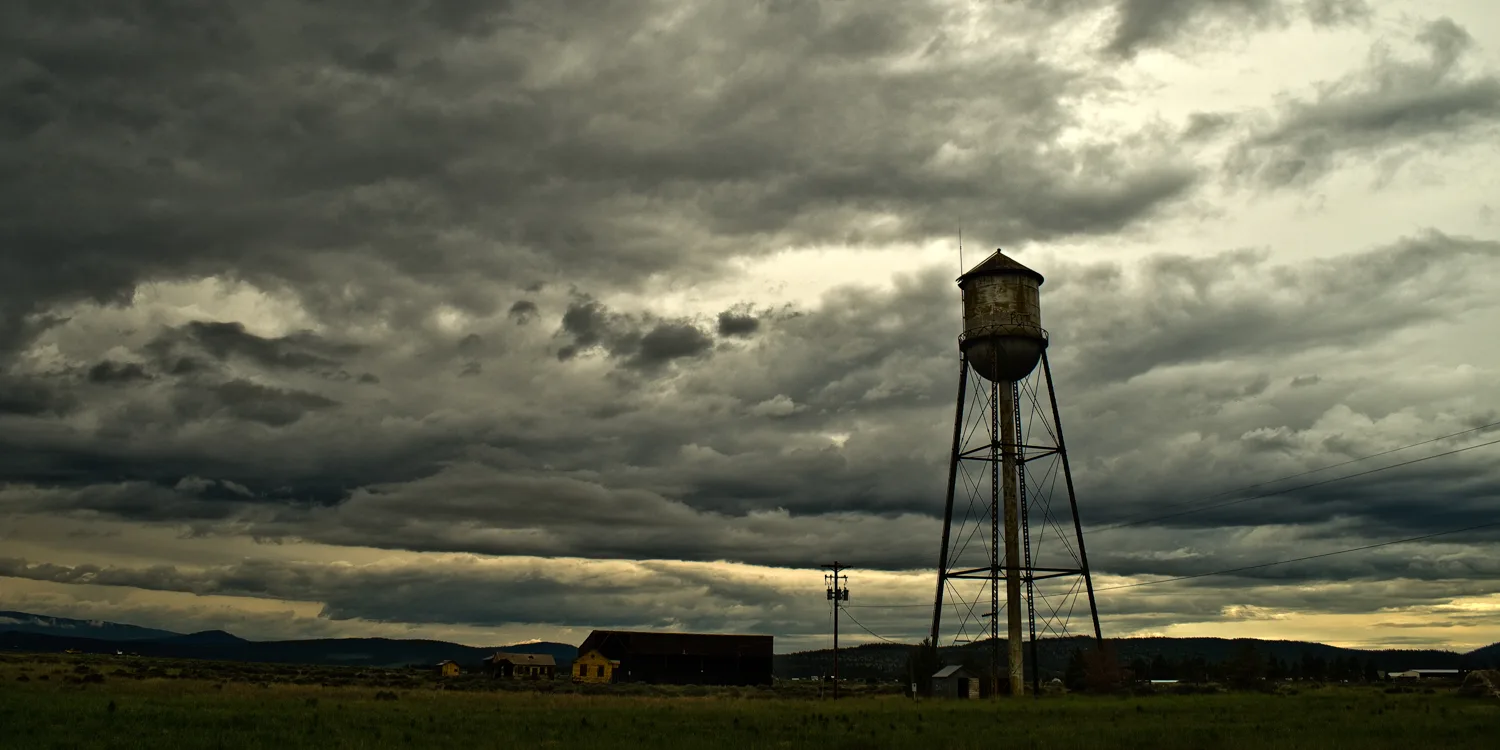 Old water tower and barn under dramatic storm clouds, Northern California — US West Coast, panoramic fine art landscape photography by Janina Laszlo