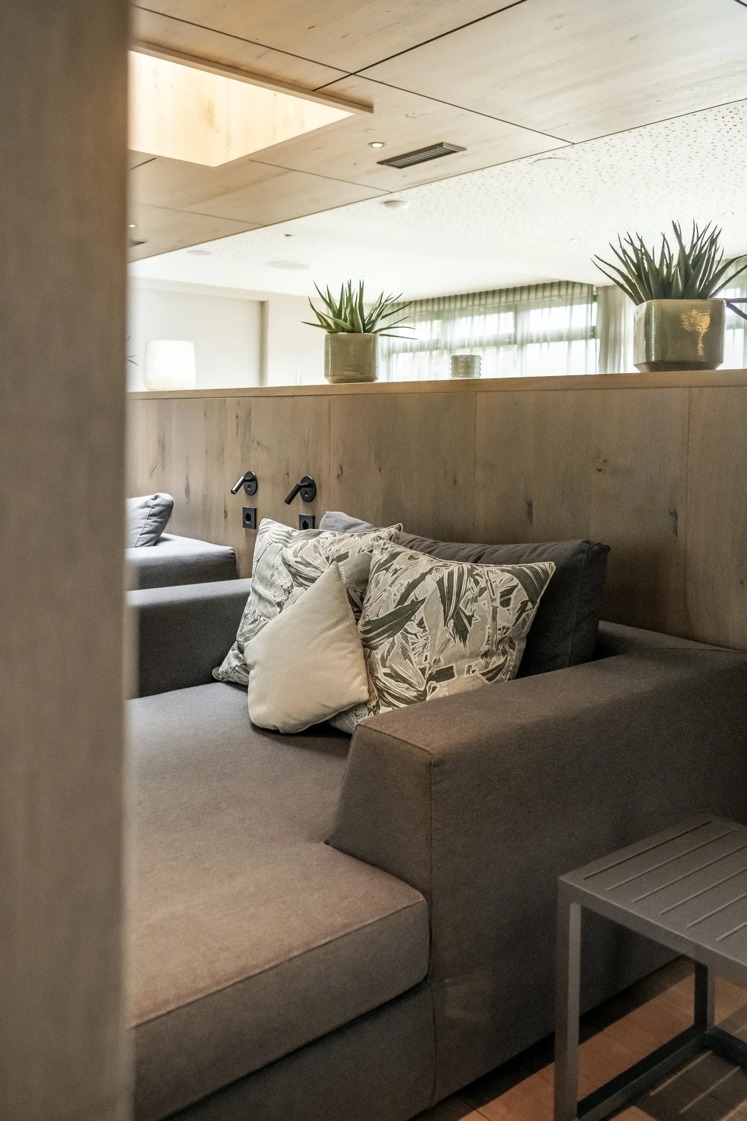 Hotel room with sofa, cushions and wood panelling at Zugspitz Resort — campaign photography by Janina Laszlo, Munich