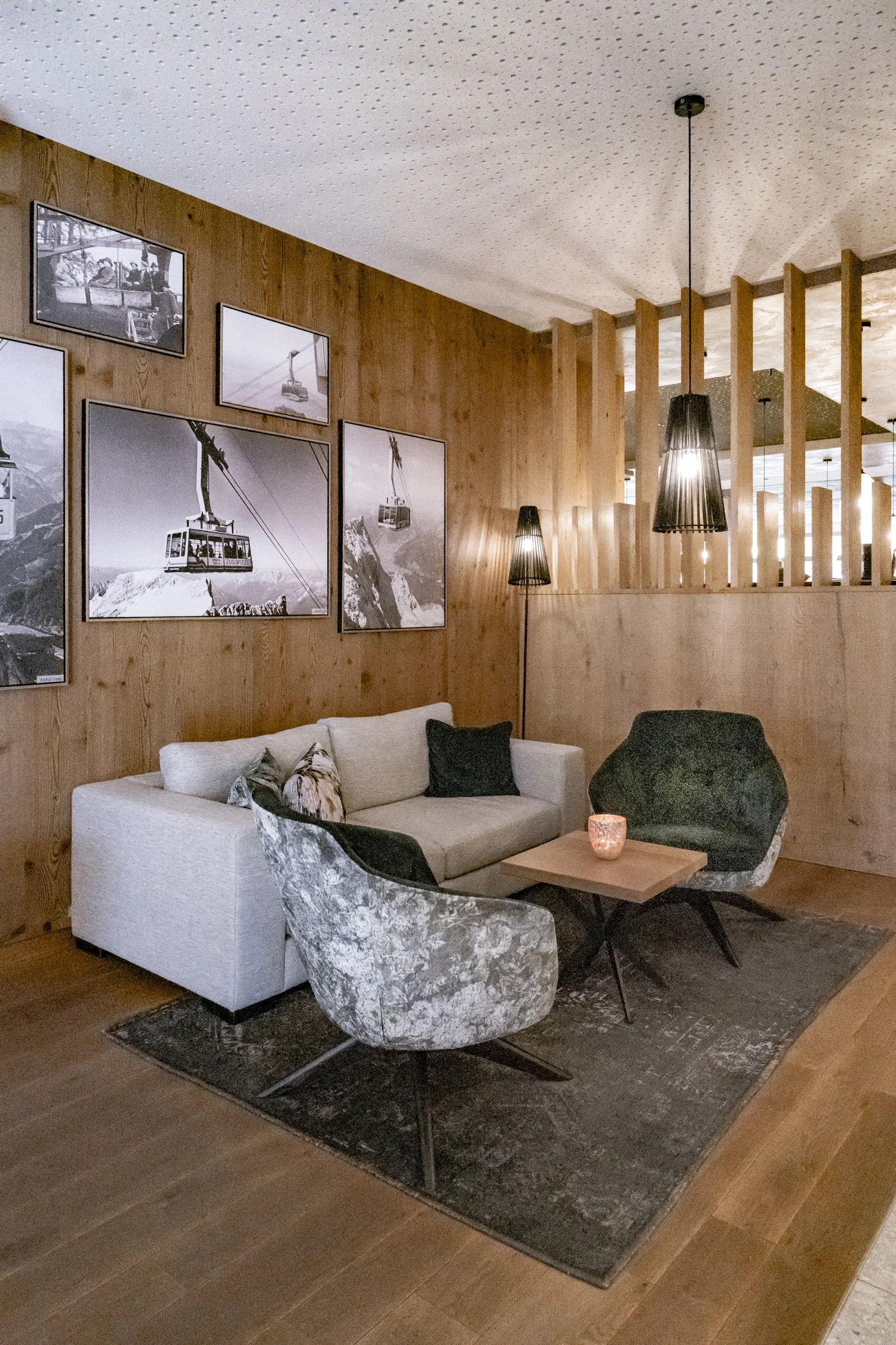Hotel lounge with velvet armchairs, wooden slats and mountain photographs, Zugspitz Resort — campaign photography by Janina Laszlo, Munich